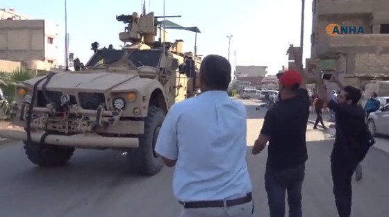 21일(현지시간) 시리아 북부 카미실리에서 철수하는 미군에 현지 주민들이 감자를 던지며 항의하고 있다. <현지언론 영상 갈무리>