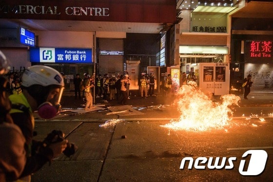 20일(현지시간) 홍콩 카우룽 지구 네이던 로드를 따라 행진하던 시위대가 던진 화염병에 사람들이 놀라고 있다. © AFP=뉴스1