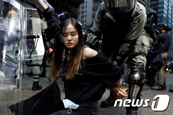 6일 홍콩 경찰들이 검은 옷을 입은 여성을 연행하고 있다. © 로이터=뉴스1