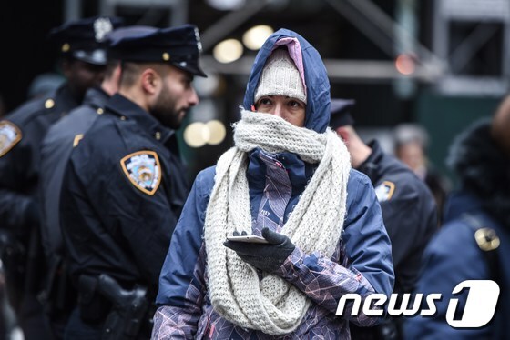 미국 뉴욕 기온이 영하권까지 떨어진 12일(현지시간) 한 뉴욕시민이 목도리와 장갑으로 중무장한 채 거리를 걷고 있다. © AFP=뉴스1