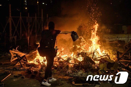 홍콩 시위대가 휘발유를 뿌리며 불을 지르고 있다. © AFP=뉴스1