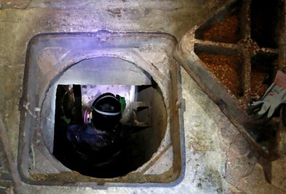 한 시위대가 탈출하기 위해 맨홀 뚜껑을 열고 하수구로 들어가고 있다. - SCMP 갈무리