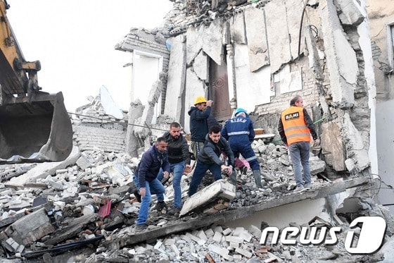26일(현지시간) 알바니아에서 규모 6.4의 강진이 발생해 수도 티라나에서 북서쪽으로 약 34㎞ 떨어진 투메인의 한 건물에서 구조대원들이 파괴된 건물 잔해를 치우고 있다. © AFP=뉴스1