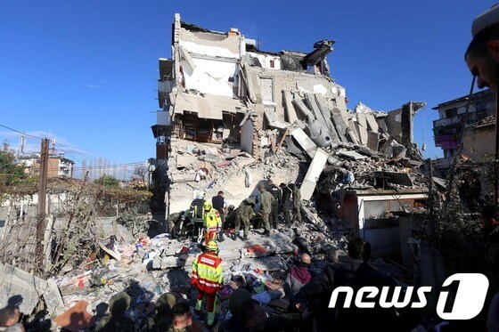 26일(현지시간) 알바니아에서 규모 6.4의 강진이 발생해 수도 티라나에서 북서쪽으로 약 34㎞ 떨어진 투메인의 한 건물에서 구조대원들이 파괴된 건물 잔해를 치우고 있다. © AFP=뉴스1