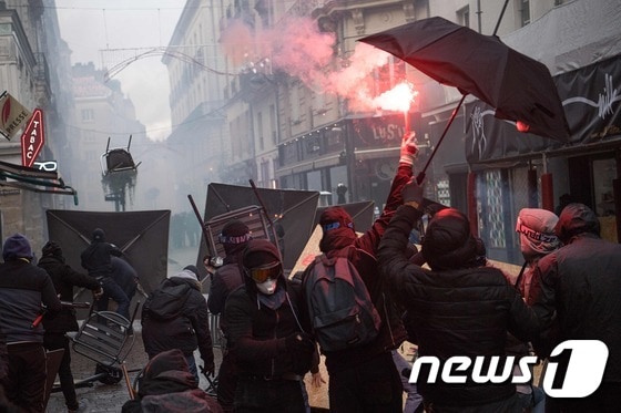 7일(현지시간) 프랑스 북서부 낭트에서 연금개편 저지 집회 도중 시위대가 경찰을 향해 의자를 던지고 있다. © AFP=뉴스1
