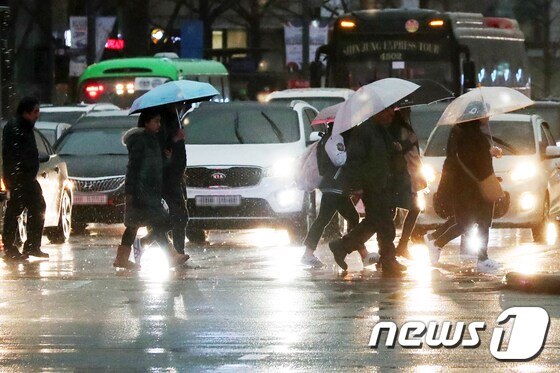 15일 오후 서울 종로구 광화문 네거리 일대에서 퇴근길 시민들이 우산을 쓰고 걸음을 재촉하고 있다.2019.3.15/뉴스1 © News1 민경석 기자