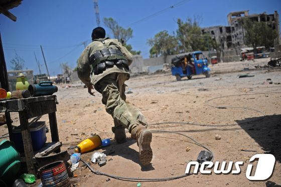 소말리아군 병사가 23일(현지시간) 폭발물이 터진 수도 모가디슈 정부 청사 인근 현장을 향해 달려가고 있다. © AFP=뉴스1