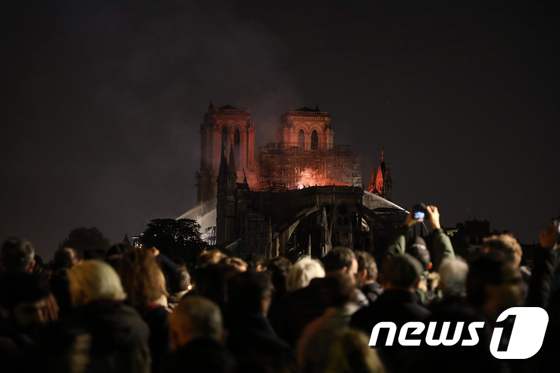 파리 시민들이 멀리서 노트르담 대성당의 화재를 지켜보고 있다. © AFP=뉴스1