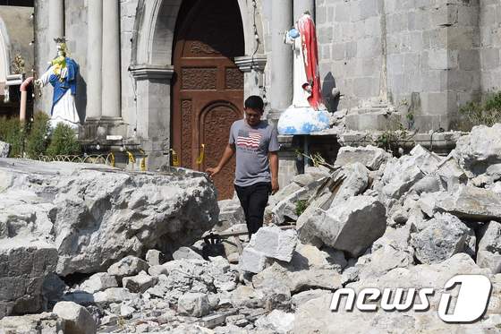 23일(현지시간) 필리핀에서 규모 6.1의 지진이 발생한 가운데 마닐라 북쪽 팜팡가 포락 타운의 교회 종탑이 무너져 돌무더기가 쌓여있다. © AFP=뉴스1 © News1 우동명 기자