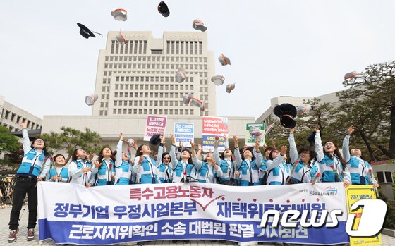 재택위탁집배원들이 23일 서울 서초동 대법원 앞에서 근로자지위확인 소송 대법원 판결 기자회견을 갖고 모자를 하늘로 던지며 승소의 기쁨을 만끽하고 있다. 2019.4.23/뉴스1 © News1 허경 기자