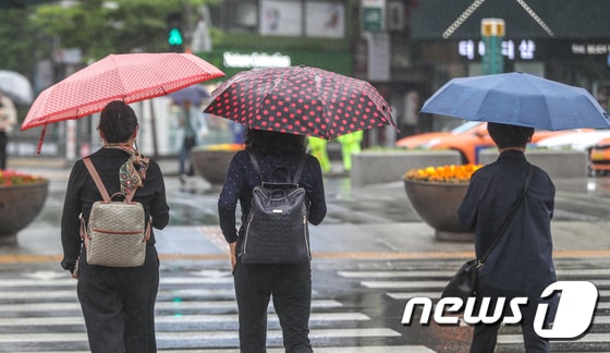 전국에 비소식이 예고된 19일 오전 서울 광화문네거리에서 시민들이 우산을 들고 발걸음을 재촉하고 있다. 2019.5.19/뉴스1 © News1 성동훈 기자