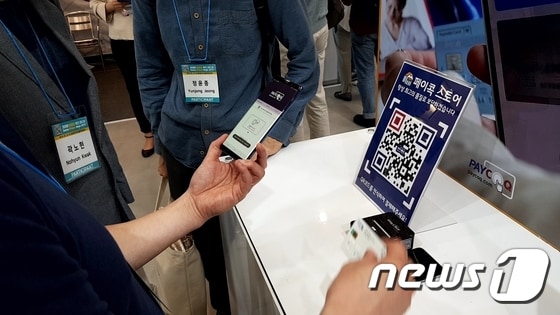 23일 '코리아 핀테크 위크 2019'에 참가한 페이콕의 한 개발자가 NFC·사진 촬영을 통한 결제 방식을 시연해보이고 있다. © 뉴스1 김도엽 기자