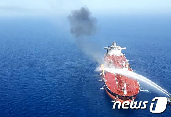 지난 13일(현지시간) 중동 호르무즈 해협 인근 오만해에서 공격을 받은 노르웨이 선적의 대형 유조선을 이란 해군이 진화를 하고 있다.  © AFP=뉴스1 © News1 우동명 기자