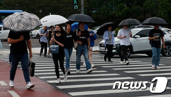 비가 내린 18일 오후 대전 유성구 충남대학교 앞 횡단보도에서 우산을 쓴 시민들이 발걸음을 재촉하고 있다. 2019.6.18/뉴스1 © News1 주기철 기자