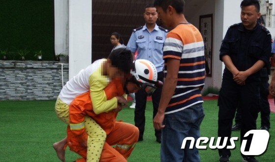 한 소방대원이 아이를 업어 안전한 곳에 내려놓고 있다 - 웨이보 갈무리