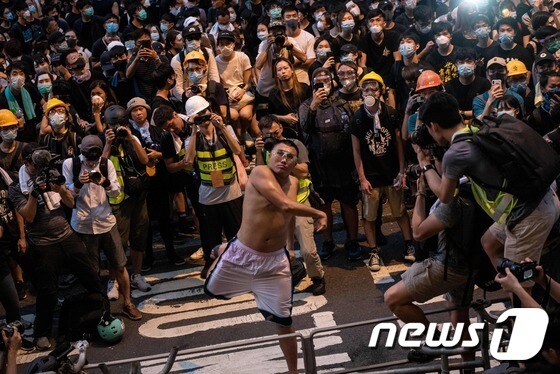 21일 한 홍콩 시민이 경찰의 과잉진압에 항의하며 경찰본부에 달걀을 투척하고 있다. © AFP=뉴스1