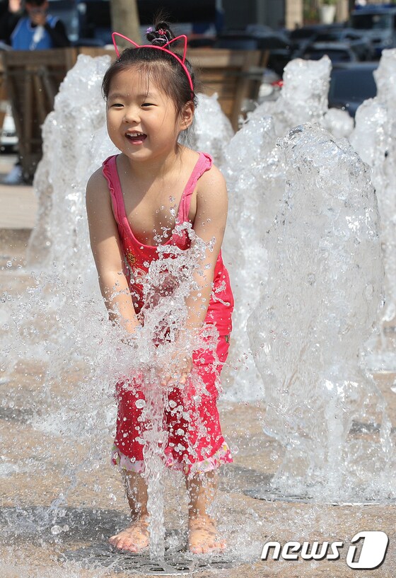 전국 최고기온이 33도 안팎까지 오른 25일 오후 서울광장 바닥분수에서 한 어린이가 물놀이를 하며 더위를 식히고 있다. 2019.6.25/뉴스1 © News1 신웅수 기자