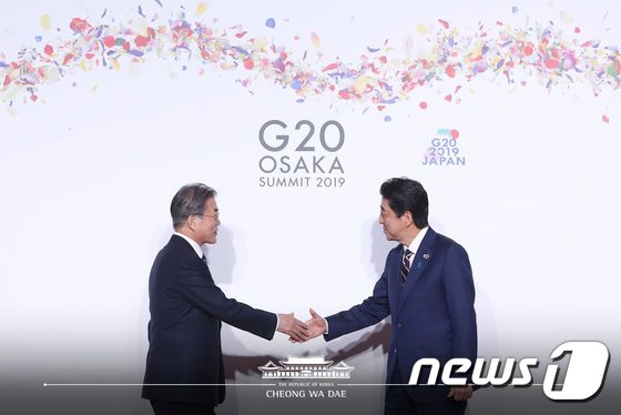 문재인 대통령이 28일 오전 인텍스 오사카에서 열린 G20 정상회의 공식환영식에서 의장국인 일본 아베 신조 총리와 악수하고 있다. (청와대 페이스북) 2019.6.28/뉴스1