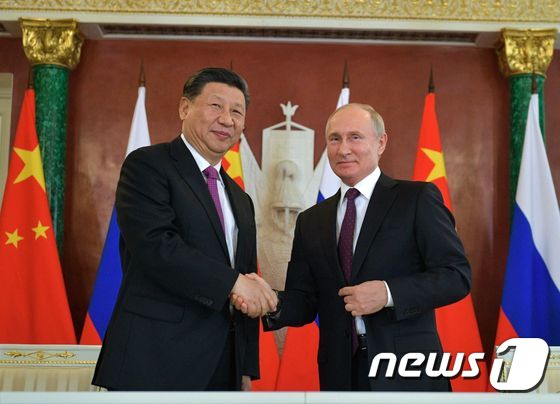 시진핑 중국 국가주석과 블라디미르 푸틴 러시아 대통령이 정상회담에 앞서 악수를 하고 있다.© AFP=뉴스1