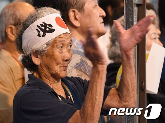 지난 2016년 7월 9일 일장기가 그려진 머리띠를 두른 한 노인이 아베 신조 일본 총리의 참의원 선거 도쿄 유세현장에서 박수를 치고 있다. © AFP=뉴스1