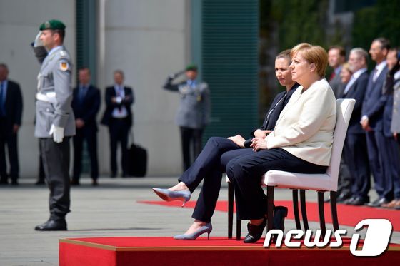 11일(현지시간) 앉아서 환영식 치르고 있는 앙겔라 메르켈 독일 총리와 메테 프레데릭센 신임 덴마크 총리 © AFP=뉴스1