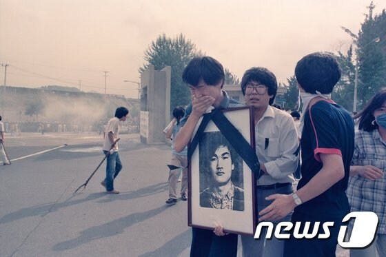 1987년 7월9일 이한열 열사의 장례식 당시 이 열사의 영정 사진을 들고 울고 있는 우상호 당시 연세대학교 학생회장. (이한열 기념사업회 제공) © 뉴스1