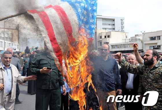 지난 4월 12일(현지시간) 이란의 수도 테헤란에서 열린 반미 집회에서 이란 시위대가 성조기를 불태우고 있다. © AFP=뉴스1