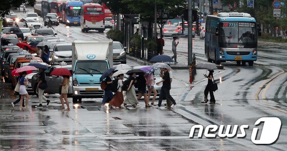 장마전선의 영향으로 전국이 흐리고 곳곳에 비가 내리는 28일 서울 마포구 동교동 삼거리에서 시민들이 우산을 쓰고 발걸음을 재촉하고 있다. 2019.7.28/뉴스1 © News1 이승배 기자