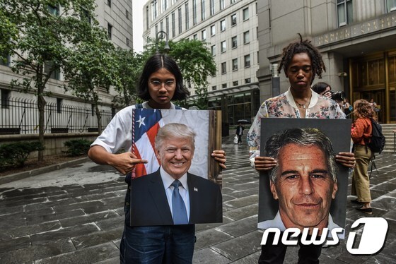 제프리 엡스타인과 도널드 트럼프 대통령의 사진을 들고 법원 앞에 서 있는 시위자들 <자료 사진>© AFP=뉴스1