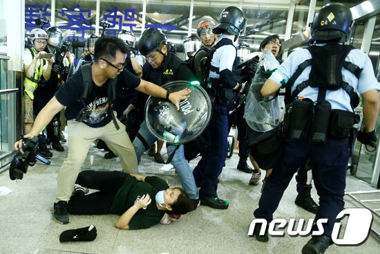13일(현지시간) 홍콩의 시위 진압 경찰이 국제공항에 진입해 시위대와 충돌하고 있다. © 뉴스1