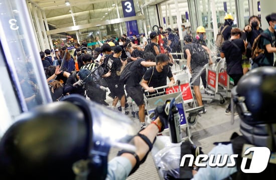 13일(현지시간) 홍콩국제공항에서 경찰과 시위대가 충돌하고 있다. © 로이터=뉴스1