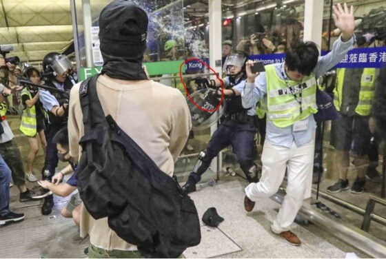 한 홍콩 경찰이 공항 시위 진압 도중 권총으로 시위대를 위협하고 있다 - SCMP 갈무리