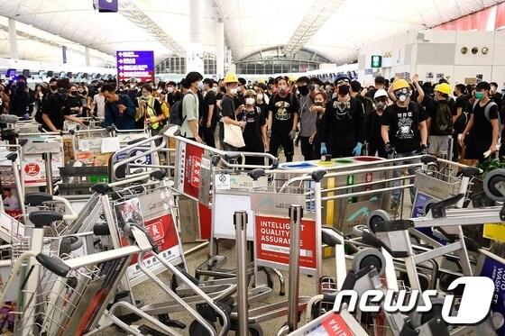 13일 밤 홍콩 국제공항에서 진압경찰이 시위대를 향해 최루액을 발사하며 해산을 시도했다. 홍콩 국제공항은 시위대의 점거가 이어지면서 13일에도 수백 편의항공편을 마비시키며 극심한 혼란을 빚었다. © AFP=뉴스1 © News1 이동원 기자