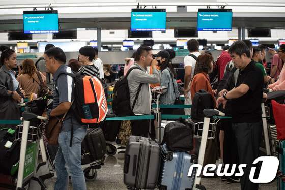 14일(현지시간) 항공편 운항이 재개되기 시작한 홍콩국제공항 출국장에서 이용객들이 탑승수속을 위해 줄을 서고 있다. © AFP=뉴스1
