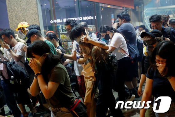 홍콩 삼수이포 거리 시위에 나선 젊은이들이 경찰이 발사한 최루탄 가스에 고통을 호소하고 있다. ©로이터=뉴스1 © News1 오대일 기자