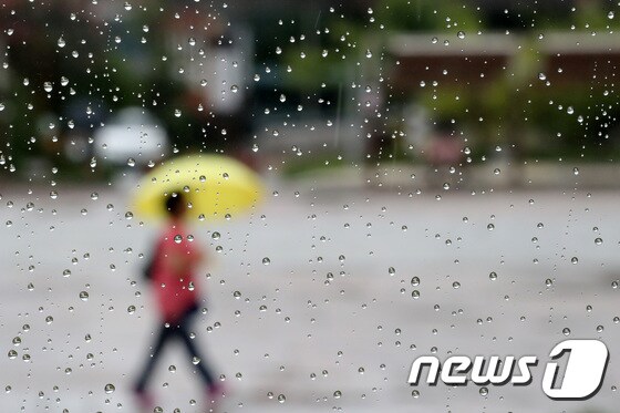 경기도 수원시 팔달구 화성행궁 광장에서 시민들이 우산을 쓴 채 걷고 있다. 뉴스1 © News1 조태형 기자
