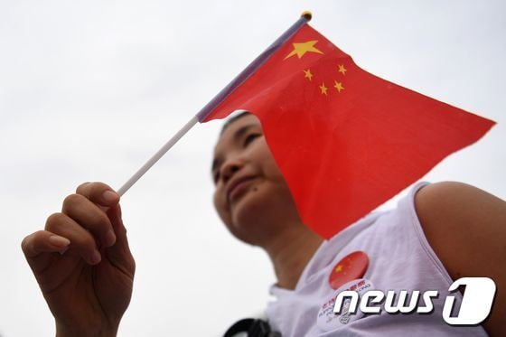 17일(현지시간) 홍콩 타마르공원에서 열린 친정부 집회 참가자가 중국 국기를 흔들고 있다. © AFP=뉴스1