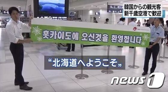 홋카이도 지방자치단체 관계자들이 19일 한국어로 환영인사가 적힌 현수막을 내걸고 한국인 관광객들을 맞이하고 있다. © 뉴스1