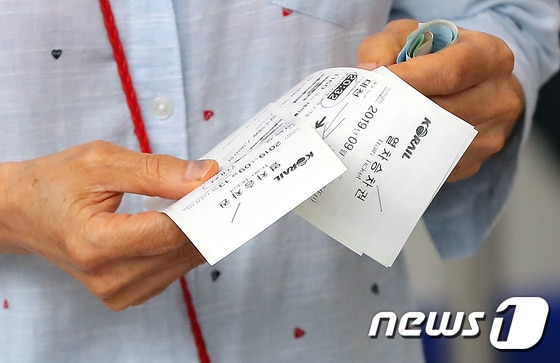 서울역에서 시민들이 추석 명절 열차 승차권을 구입한 뒤 표를 확인하고 있다.(특정 기사 내용과 관계 없음) 8.21 구윤성 기자