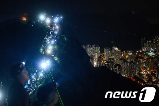 시위대가 휴대폰 손전등 기능을 이용, 촛불시위를 펼치고 있다. © AFP=뉴스1