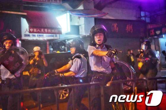 홍콩 경찰이 25일 홍콩 췬완에서 시위대를 향해 권총을 겨누고 있다. © AFP=뉴스1 © AFP=뉴스1