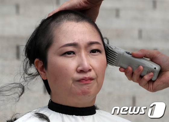 이언주(무소속) 의원이 10일 서울 여의도 국회 본청 계단에서 삭발식을 하고 있다. 이 의원은 '조국 임명 규탄