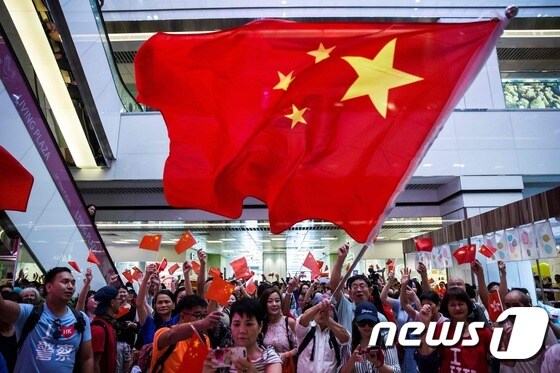 14일(현지시간) 홍콩의 한 쇼핑단지에서 친중 시위대가 중국 오성홍기를 흔들고 있다. © AFP=뉴스1