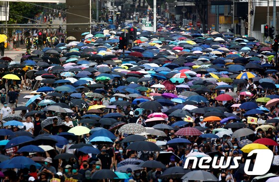 15일 송환법 철회 발표 이후에도 행정장관 직선제 등을 요구하는 홍콩 시위대가 우산을 들고 행진하고 있다. © 로이터=뉴스1 © News1 우동명 기자