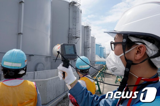 지난 2018년 7월27일 도쿄전력 직원들이 후쿠시마 제1원전 1호기의 방사능 오염수 저장탱크 주변에서 방사능 수치를 측정하고 있다. © AFP=뉴스1