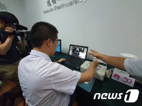 중국 청두시 제3인민병원에서 원격의료를 하는 모습. 노트북 화면에 보이는 곳은 이곳에서 약 1700㎞ 떨어진 선전시 화웨이 리서치랩이다. 의사가 의료용 기기를 움직이자 선전시에 있는 의료용 로봇팔이 그대로 움직였다.  © 뉴스1