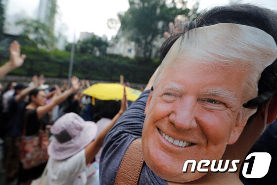 한 시민이 트럼프 대통령의 가면을 쓰고 시위에 참여하고 있다. © 로이터=뉴스1