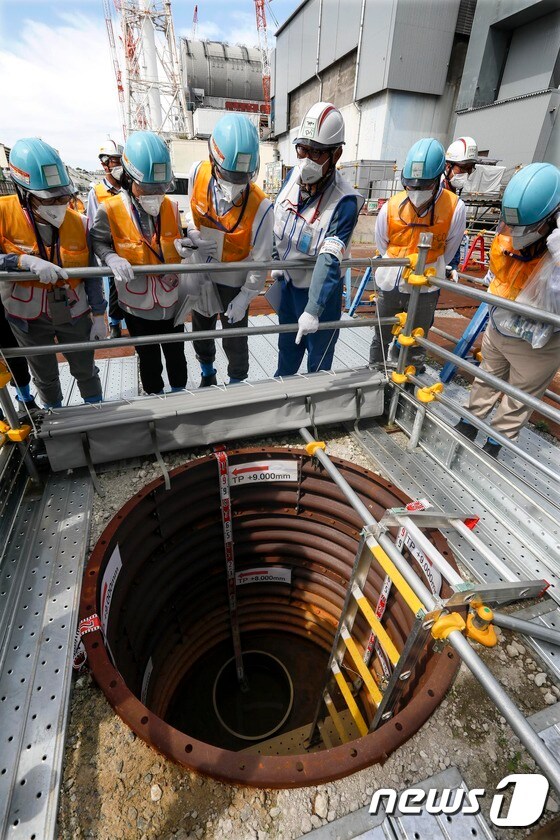 일본 도쿄전력 직원(오른쪽에서 세번째)이 지난 2018년 7월30일 후쿠시마 제1원자력발전소 부지 내에서 외신기자들을 상대로 '동토차수벽'과 지하수 수위 측정용 우물 등에 대해 설명하고 있다. © AFP=뉴스1