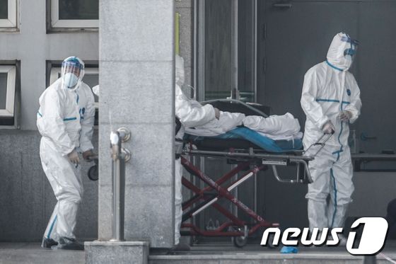 20일(현지시간) 중국 후베이성 우한의 한 병원에서 직원들이 '우한 폐렴' 환자를 옮기고 있다. 중국에서는 이날까지 ‘우한 폐렴’의 4번째 사망자가 나왔다. © AFP=뉴스1 © News1 우동명 기자
