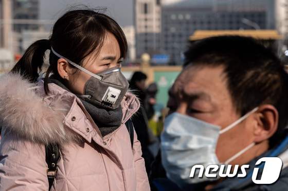 21일 (현지시간) 신종 코로나바이러스인 우한 폐렴의 감염을 피하기 위해 시민들이 마스크를 쓴 채 베이징 지하철 밖 경찰서 앞을 지나고 있다. © AFP=뉴스1 © News1 우동명 기자